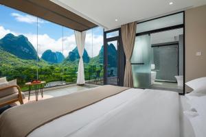 a bedroom with a large bed and a large window at Dreamland Inn in Yangshuo