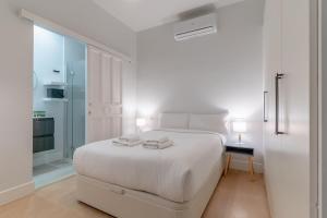 ein weißes Schlafzimmer mit einem weißen Bett und einem Fenster in der Unterkunft Cozy and Central-1Bd 1Bth- Cortes in Madrid