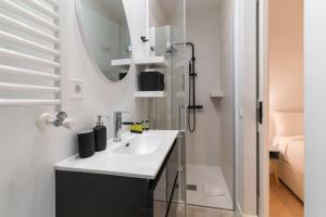 ein Bad mit einem Waschbecken und einem Spiegel in der Unterkunft Cozy and Central-1Bd 1Bth- Cortes in Madrid