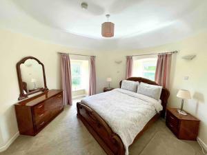 1 dormitorio con 1 cama grande y espejo en Beautiful Farmhouse an Hour’s Drive From Four Irish Cities en Clonmel