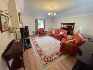 een woonkamer met rode meubels en een piano bij Beautiful Farmhouse an Hour’s Drive From Four Irish Cities in Clonmel