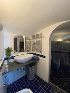 uma casa de banho com uma banheira, um lavatório e espelhos em Monacone vista mare em Capri