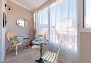 Zimmer mit einem Tisch, Stühlen und einem Fenster in der Unterkunft MY CASA LAMARTINE - Studio w/ terrace and AC very central in Nizza