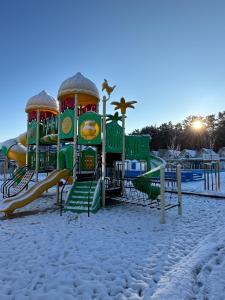 a playground in the snow with a slide at Holiday Park & Resort Rowy in Rowy