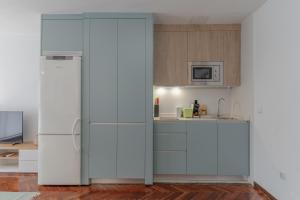 a kitchen with white cabinets and a refrigerator at Brigth Stylish studio - Gran Vía in Madrid