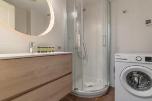 a bathroom with a washing machine and a mirror at Brigth Stylish studio - Gran Vía in Madrid