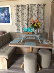 - Mesa de centro con sofá y mesa con flores en Pinto Holiday Home Oakdene Forest Park Passes Inc!, en Ringwood