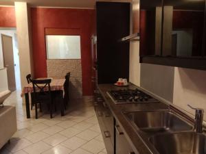uma cozinha com um lavatório e um fogão forno superior em Appartamento vicino ai laghi e aeroporto di Malpensa em Gallarate