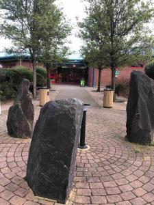 a statue of two large rocks in front of a building at Pinto Holiday Home Oakdene Forest Park Passes Inc! in Ringwood