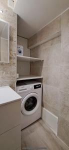 een wasmachine en droger in een kleine keuken bij T2, T3 coeur de ville, patio, clim et parking privé in Sète