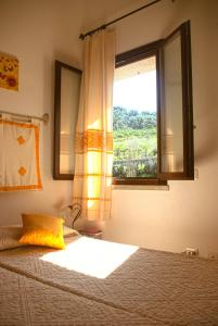 a bedroom with a bed with a window at Villa Louise in Costa Rei