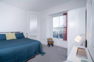 アンブルサイドにあるTop of the Bank Apartmentの白いベッドルーム(青いベッド1台、窓付)