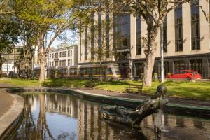 a statue in a pond in front of a building at Ashling Hotel Dublin in Dublin