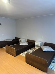 drie bedden in een kamer met houten vloeren bij Apartament Morskie Oko in Brodnica