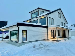 ein Haus im Winter mit Schnee auf dem Boden in der Unterkunft Arctic Sea Breeze in Kirkenes