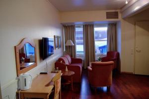 a hotel room with chairs and a table and a mirror at True Vesterålen Hotel in Sortland