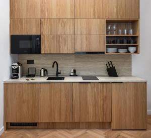 a kitchen with wooden cabinets and a sink at R16 Residences Prague in Prague