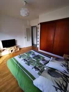 - une chambre avec un grand lit et une tête de lit en bois dans l'établissement Beau T1 Spacieux, Proche Centre et lac, à Annecy