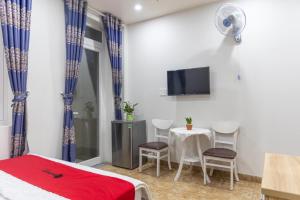 Habitación con cama, mesa y TV. en Rita Hotel Home- Airport Tân Sơn Nhất- Cạnh Bệnh Viện Tâm Anh & Gần Quân Khu 7 en Ho Chi Minh