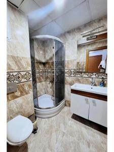a bathroom with a shower and a toilet and a sink at 歆驿时光 in Esenyurt