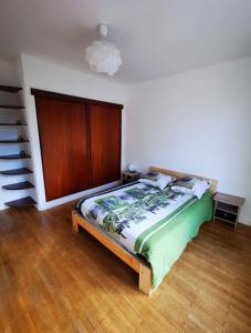 - une chambre avec un lit et une tête de lit en bois dans l'établissement Beau T1 Spacieux, Proche Centre et lac, à Annecy