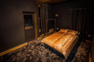 - une chambre avec un lit dans une pièce sombre dans l'établissement Beautiful 2-Bed Haven In Chelsea, à Londres