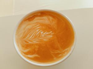 Una taza de café con una hoja pintada. en Dreamland Inn, en Yangshuo