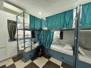 Cette chambre dispose de 3 lits superposés et de portes bleues. dans l'établissement 12 Monks Rishikesh Hostel, à Rishikesh