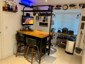 a kitchen with a bar with stools in a room at Driver Way in Wellingborough