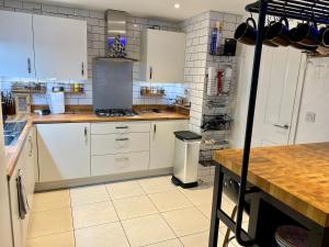 una cucina con armadi bianchi e piano di lavoro di Driver Way a Wellingborough