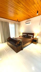 a bedroom with a large bed and a wooden ceiling at Rani Suite and Cabin in Kandy