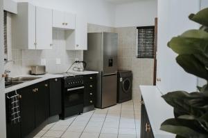 a kitchen with black cabinets and a stainless steel refrigerator at @Kruger in White River
