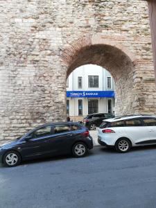 twee auto's geparkeerd voor een bakstenen gebouw bij No 1 House By Valence in Istanbul