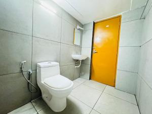 La salle de bains est pourvue de toilettes et d'une porte jaune. dans l'établissement HERITAGE HOMES, à Ernakulam