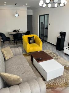 - un salon avec un canapé et un fauteuil jaune dans l'établissement Starroot Residences, à Nairobi