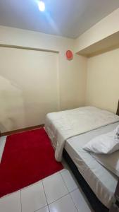 - une chambre avec 2 lits et un tapis rouge dans l'établissement INPRO PROPERTY, à Bandung