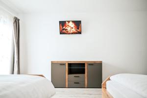 1 dormitorio con 2 camas y TV en la pared en Pensiunea Abrudan, en Scrind-Frăsinet