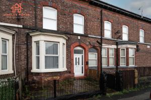 an old brick house with a white door at Spacious 5-Bedroom Oasis with Games Room-Liverpool in Liverpool