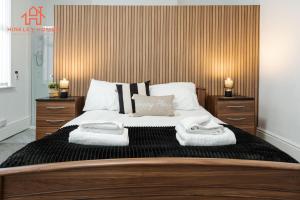 Spacious 5-Bedroom Oasis with Games Room-Liverpool في ليفربول: غرفة نوم بسرير كبير عليها مناشف