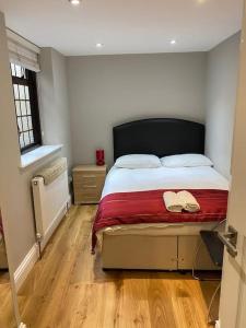 ロンドンにあるClarendon Apartment Holland Parkのベッドルーム1室(赤毛布付きの大型ベッド1台付)