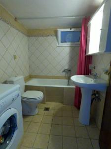 a bathroom with a toilet and a tub and a sink at Ioannis & Labros House in Vlikhón