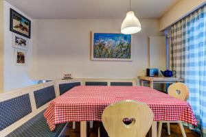 mesa de comedor con mantel a cuadros rojo y blanco en Appartement Nevada 104 Spa en La Tzoumaz