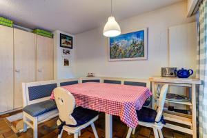 una cocina con mesa y 2 sillas y una mesa en rojo y blanco en Appartement Nevada 104 Spa en La Tzoumaz