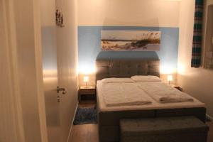 une chambre avec un lit et un tableau au mur dans l'établissement Fewo Möwe Lütow Usedom Achterwasser blaues Haus, à Lütow