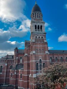 a building with a clock tower on top of it at Your homestay in a bibliophile mansion in Antwerp