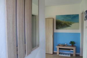 une chambre avec une table et une photo de la plage dans l'établissement Fewo Möwe Lütow Usedom Achterwasser blaues Haus, à Lütow