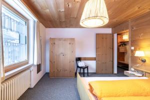 a bedroom with a yellow bed and a window at Chasa Val 2 in Scuol