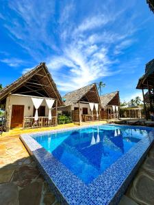 una piscina frente a una villa en Bitcoin Beach Hotel Zanzibar en Pingwe