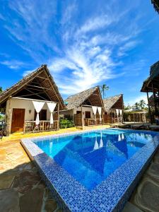 a swimming pool in front of a villa at Bitcoin Beach Hotel Zanzibar in Pingwe