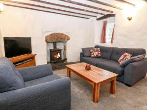 uma sala de estar com dois sofás e uma lareira em Is Y Graig em Caernarfon